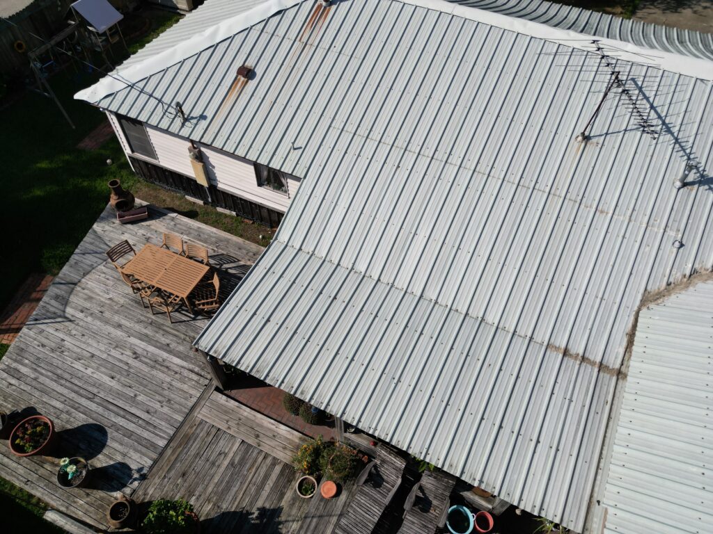 residential corrugated metal roof and a wooden deck with outdoor seating
